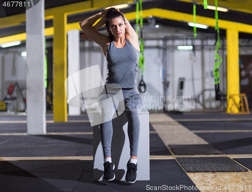 Image of woman warming up and stretching on fit box