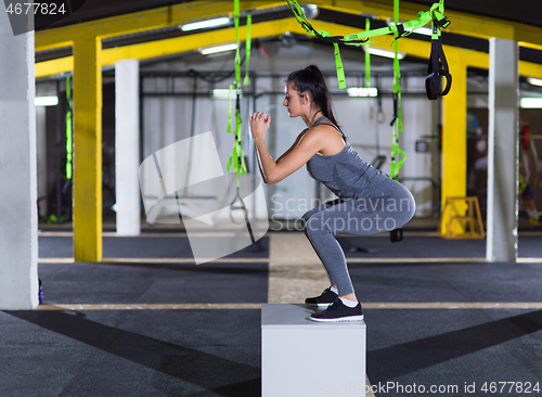 Image of woman working out  jumping on fit box