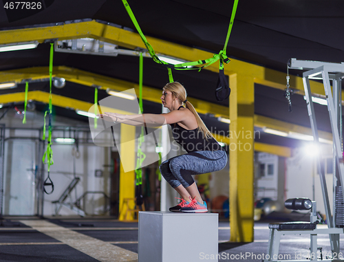 Image of woman working out  jumping on fit box