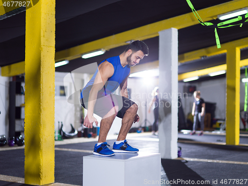 Image of man working out jumping on fit box