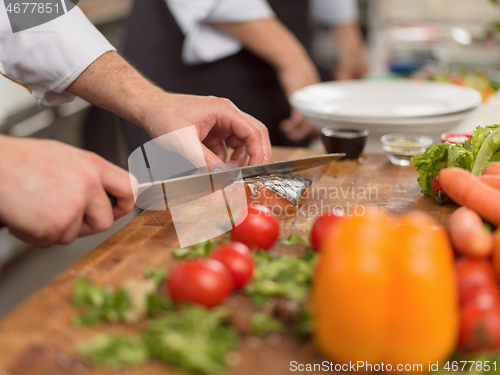 Image of Chef hands preparing marinated Salmon fish