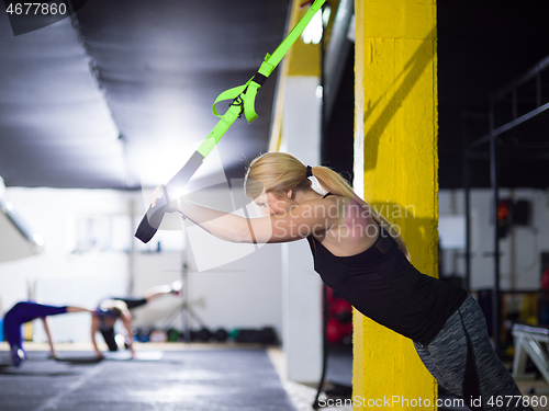 Image of woman working out pull ups with gymnastic rings