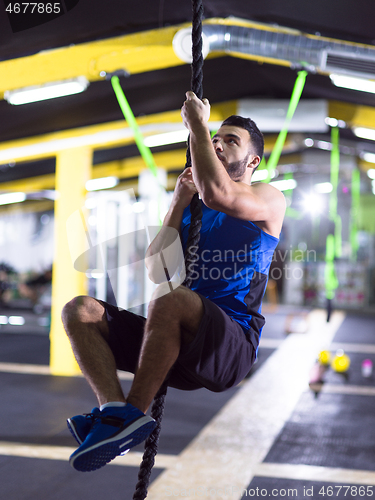 Image of man doing rope climbing