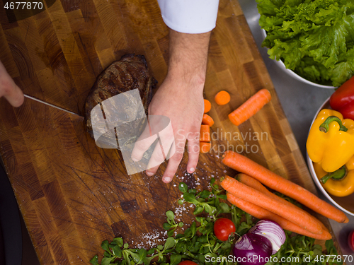 Image of closeup of Chef hands preparing beef steak