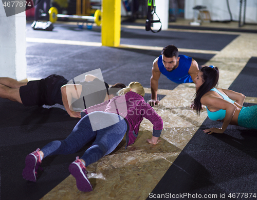 Image of young healthy people doing pushups