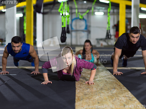 Image of young healthy people doing pushups