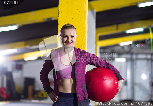 Image of portrait of woman with red crossfitness ball