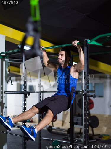 Image of man doing pull ups on the horizontal bar