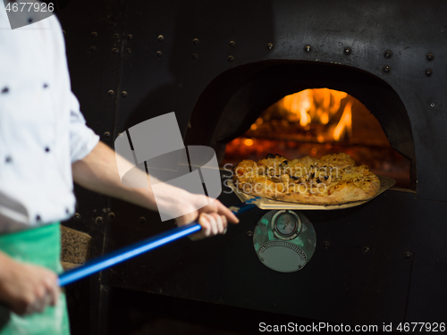 Image of chef removing hot pizza from stove