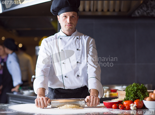 Image of chef preparing dough for pizza with rolling pin