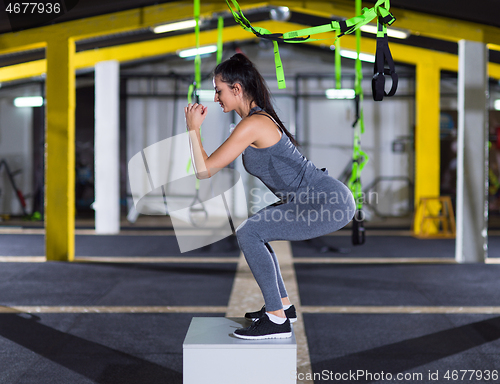 Image of woman working out  jumping on fit box