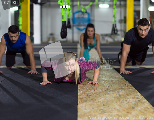 Image of young healthy people doing pushups