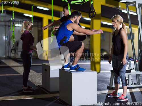 Image of athletes working out  jumping on fit box