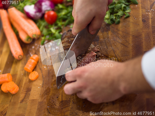 Image of closeup of Chef hands preparing beef steak