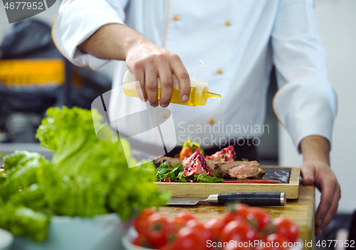 Image of Chef finishing steak meat plate