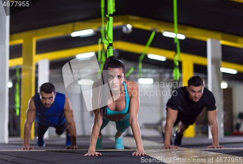 Image of young healthy people doing pushups