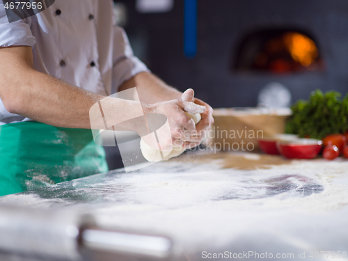 Image of chef hands preparing dough for pizza