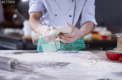 Image of chef hands preparing dough for pizza