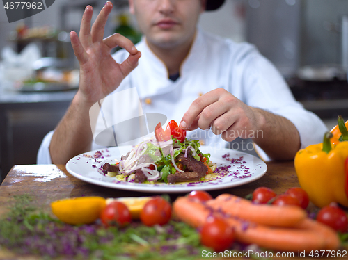 Image of cook chef decorating garnishing prepared meal