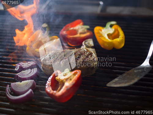 Image of chef cooking steak with vegetables on a barbecue