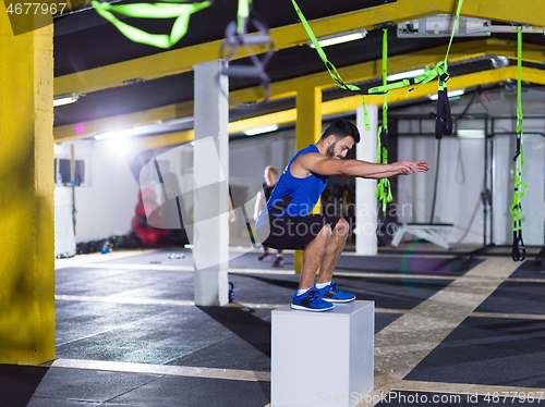 Image of man working out jumping on fit box