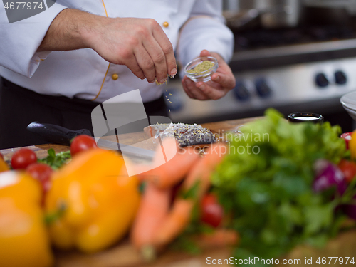 Image of Chef hands preparing marinated Salmon fish