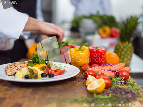 Image of cook chef decorating garnishing prepared meal