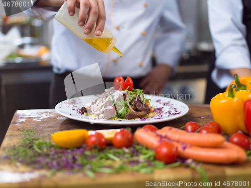 Image of Chef finishing steak meat plate