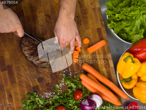 Image of closeup of Chef hands preparing beef steak