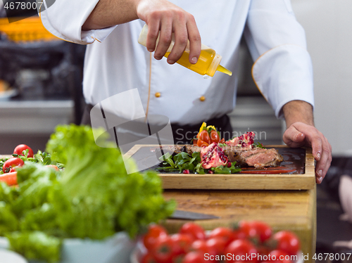 Image of Chef finishing steak meat plate