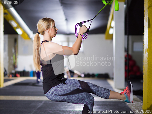 Image of woman working out pull ups with gymnastic rings