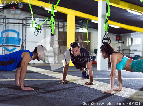 Image of young healthy people doing pushups