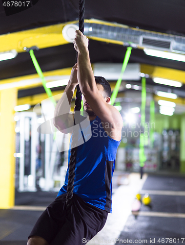 Image of man doing rope climbing