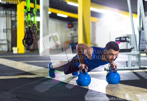 Image of Young strong man doing pushups