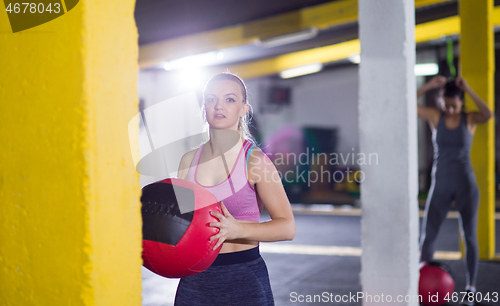 Image of portrait of woman with red crossfitness ball
