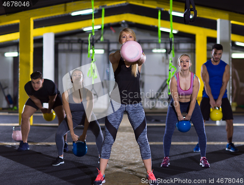 Image of athletes doing exercises with kettlebells