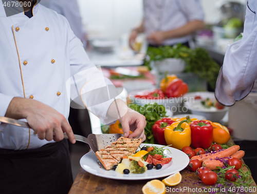 Image of cook chef decorating garnishing prepared meal