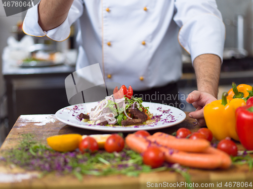 Image of cook chef decorating garnishing prepared meal