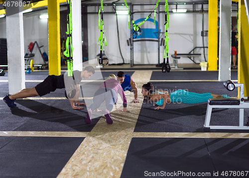 Image of young healthy people doing pushups