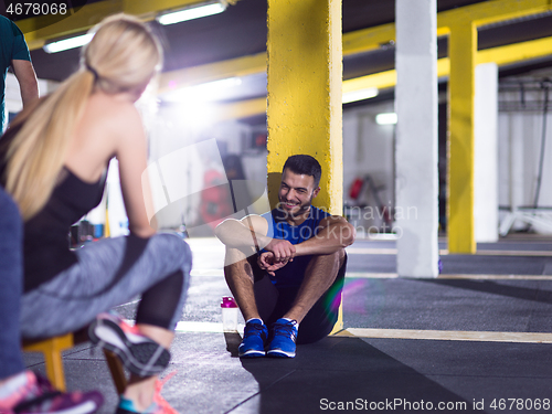 Image of young athletes sitting on the floor and relaxing