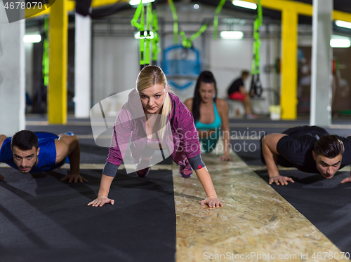 Image of young healthy people doing pushups