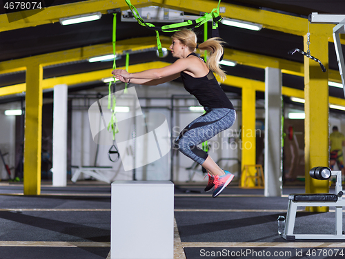 Image of woman working out  jumping on fit box