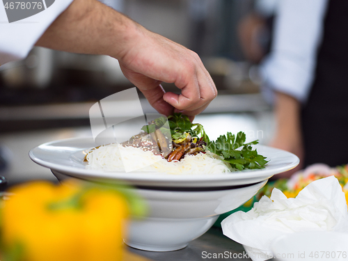 Image of Chef hands serving spaghetti