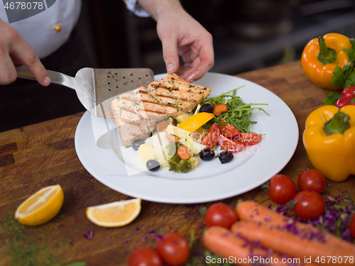 Image of cook chef decorating garnishing prepared meal