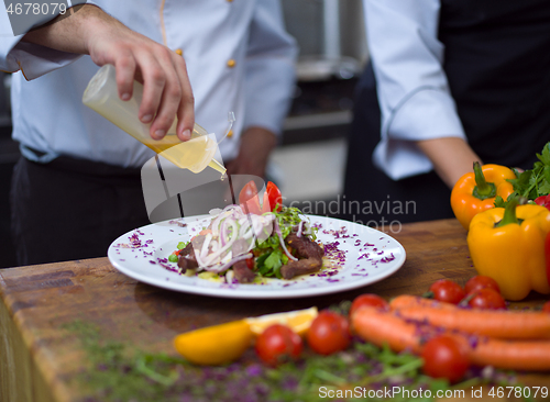 Image of Chef finishing steak meat plate