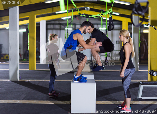 Image of athletes working out  jumping on fit box