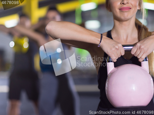 Image of athletes doing exercises with kettlebells