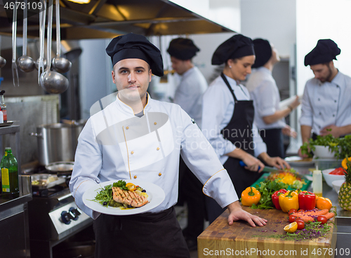Image of Chef holding dish of fried Salmon fish fillet