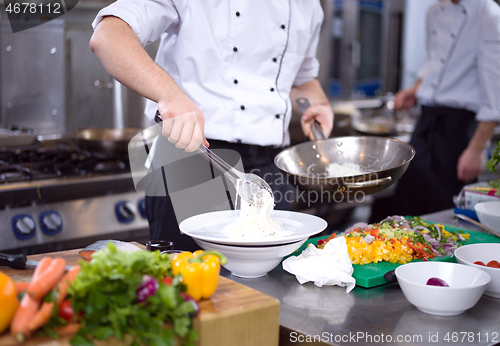 Image of Chef hands serving spaghetti