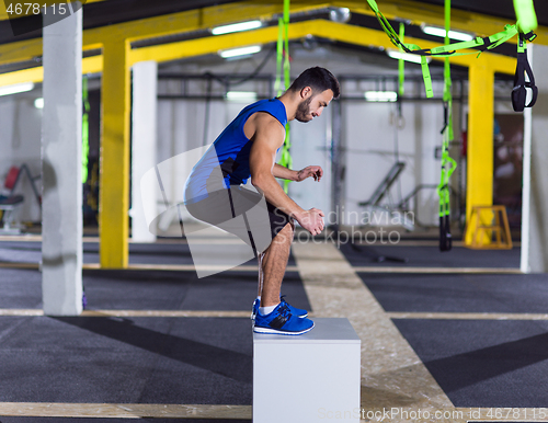 Image of man working out jumping on fit box